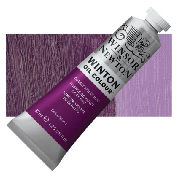 A tube of Cobalt Violet Hue Winsor and Newton Winton Oil Paint 37ml is shown diagonally, across the center of the frame. The tube is a silver colour and has a white screw on, plastic lid. The Winsor and Newton logo is printed at the top of the tube and there is a white band printed across the tube, below the logo, that has the words 'Winton Oil Colour' written on it. Below that is a colour band printed across the tube that has black text describing the product colour and paint properties. There is a rectangular colour swatch behind the tube that shows the colour of the paint. It lays horizontally across the top third of the frame. The image is center of the frame and on a white background.