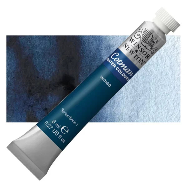 A single Indigo Winsor and Newton Cotman Watercolour 8ml Tube is shown diagonally across the frame. The back of the tube is facing the bottom left hand corner of the frame and the lid of the tube is facing the top, right hand corner of the frame. The tube is silver and the Winsor and Newton logo is printed at the top of the tube. There is a blue band below the logo and the words 'Cotman Watercolour' are printed on the blue band in white. Then there is a large colour band around the base of the tube that denotes the colour of the paint. The tube colour and paint properties are indicated on this colour band in black text. The tube has a white, plastic screw on cap. There is a rectangular colour swatch behind the tube that shows how the colour works on a gradient scale. The entire image is center of the frame and on a white background.