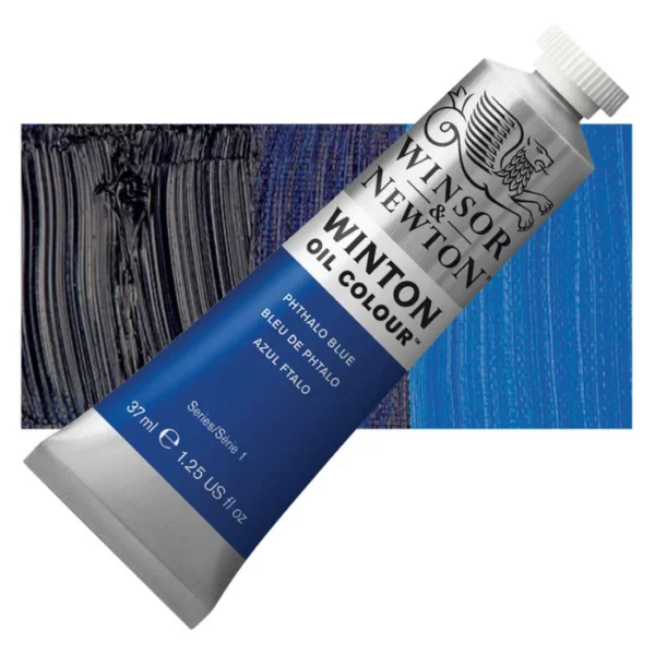 A tube of Phthalo Blue Winsor and Newton Winton Oil Paint 37ml is shown diagonally, across the center of the frame. The tube is a silver colour and has a white screw on, plastic lid. The Winsor and Newton logo is printed at the top of the tube and there is a white band printed across the tube, below the logo, that has the words 'Winton Oil Colour' written on it. Below that is a colour band printed across the tube that has black text describing the product colour and paint properties. There is a rectangular colour swatch behind the tube that shows the colour of the paint. It lays horizontally across the top third of the frame. The image is center of the frame and on a white background.