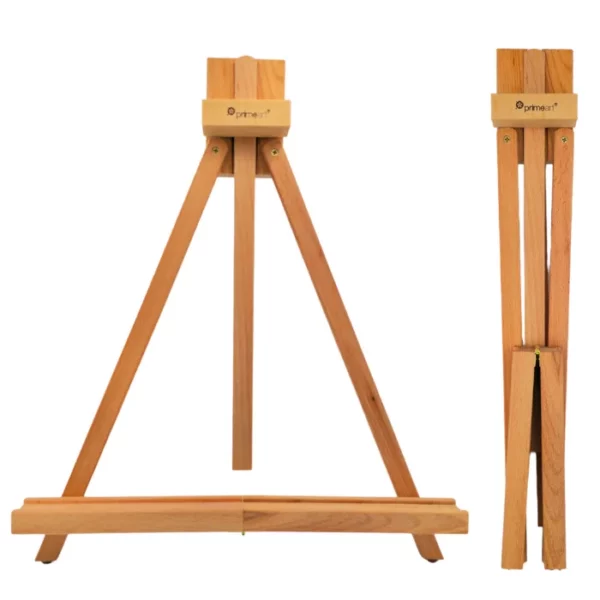 A single wooden Prime Art Compact Wooden Table Easel - A Frame is shown in the center of the frame, with a closed version of the easel, shown along the right hand side of the frame, this shows how the easels compacts. The easel is made out of a pine wood and has the Prime Art logo burnt into the top of the wood. It is an A Frame, desk top, sized easel that folds away for easy storage. On a white background.