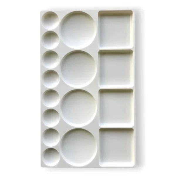 A Prime Art Plastic Palette 16 Well Rectangular is shown, vertically in the center of the frame. The palette is made of a white plastic and has 16 wells to hold colour. Some of the wells are circular and some are rectangular. The image is center of the frame and on a white background.