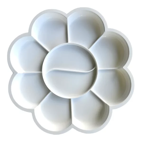 A Prime Art Plastic Palette 8 Well Flower is shown in the center of the frame. The palette is a round flower shape and made of a white plastic. It has 8 wells to hold paint. The image is center of the frame and on a white background.