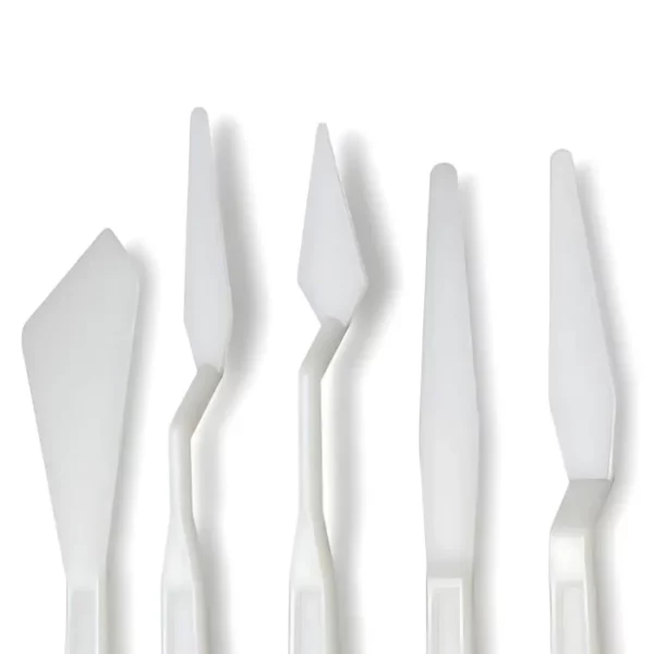 The loose knives from a Prime Art Plastic Palette Knife Set is shown in the frame, The white plastic knives are lined up next to each other vertically across the center of the frame. Each knife has a different shaped plastic blade. This image is a close up if the plastic blades at the bottom of the knives are cut off by the bottom of the frame.