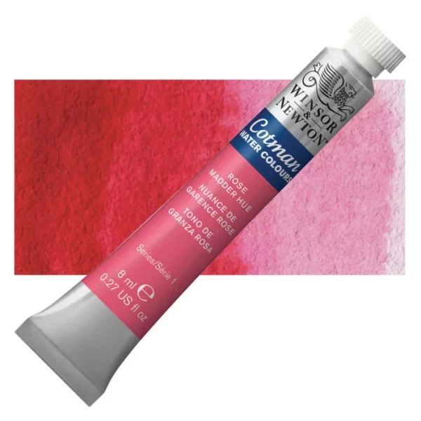 A single Rose Madder Hue Winsor and Newton Cotman Watercolour 8ml Tube is shown diagonally across the frame. The back of the tube is facing the bottom left hand corner of the frame and the lid of the tube is facing the top, right hand corner of the frame. The tube is silver and the Winsor and Newton logo is printed at the top of the tube. There is a blue band below the logo and the words 'Cotman Watercolour' are printed on the blue band in white. Then there is a large colour band around the base of the tube that denotes the colour of the paint. The tube colour and paint properties are indicated on this colour band in black text. The tube has a white, plastic screw on cap. There is a rectangular colour swatch behind the tube that shows how the colour works on a gradient scale. The entire image is center of the frame and on a white background.