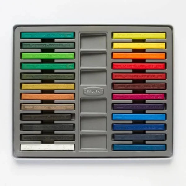 The inside tray of a Set of 24 Derwent Inktense Blocks is shown horizontally in the center of the frame. The block sticks are lined up next to each other. Each stick is a different colour. On a white background.