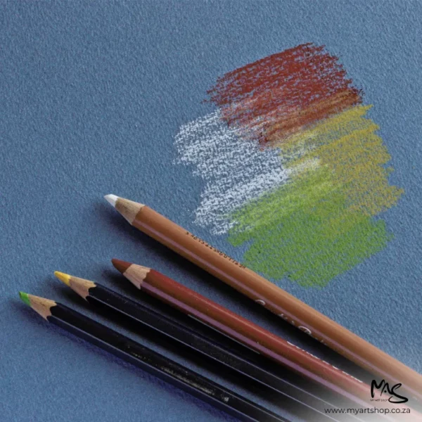 A close up of 4 chalk pastel pencils in green, yellow, red and white, applying some colour to a sheet of Fabriano Cromia Paper. The image is cut off by the frame. The paper is blue.