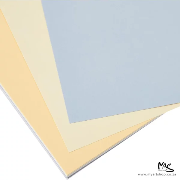 A close up of some sheets of paper from the Soft Colours Fabriano Tiziano Pastel Paper Pad are shown fanned across the frame. Only the corners of the sheets can be seen, and the paper is cut off by the top and left hand side of the frame. On a white background.