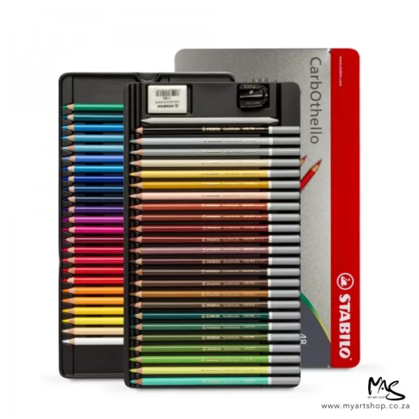 A Stabilo CarbOthello Chalk Pastel Pencil Set of 48 can be seen standing vertically in the center of the frame. The 2 trays of pencils are removed from the set and are shown staggered on top of each other and the tin is in the background. The image is center of the frame and on white background.