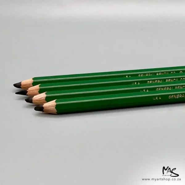 There are 4 9XXB Kimberley Drawing Pencils from the General Pencil Co. seen coming out of the right hand side of the frame at a slight angle. The pencils have a green barrel and are sharpened. They are on a light grey background.