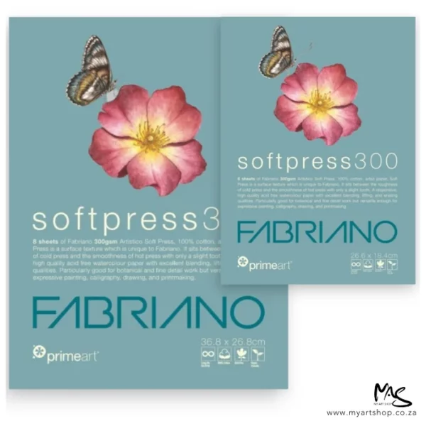 There are two Prime Art Fabriano Soft Press Pads in the frame. The pad to the back and along the left hand side of the frame is larger than the pad at the front, which overlaps the back pad. Both pads have a dusty blue cover with a picture of a pink flower and a butterfly on the cover. There is white and blue text below the image that describes the quality of the pad and has the brand name. The image is center of the frame and on a white background.