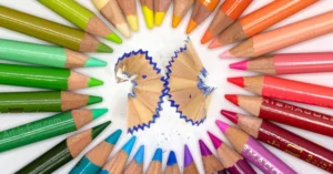 A circle has been made using Prismacolor Coloured Pencils in a rainbow pattern. The pencil leads are pointing towards the center of the frame forming a circle. Each pencil is a different colour.