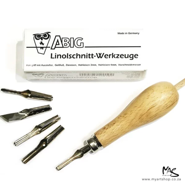 A set of ABIG Lino Cutting Tools is shown in the frame. The white box with black print that houses the set is shown in the background and the wooden handle is in front of the box, one blade is attached to the wooden handle. The remaining 4 blades are fanned out in front of the handle. The image is on a white background.