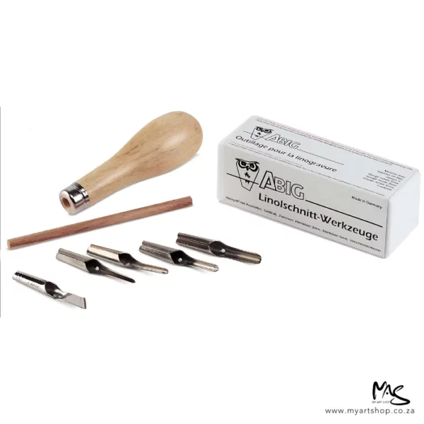 A set of ABIG Lino Cutting Tools can be seen in the frame. The printed white box that houses the contents is shown in the background. The wooden handle is shown to the left of box and there is a wooden dowel in front of the handle. The 5 metal blades are lined up in front of the wooden dowel. The image is on a white background.