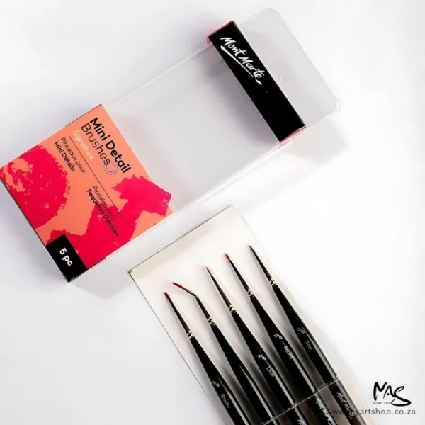 An open Mont Marte Mini Detail Brush Set 5 Piece is seen in the frame. The clear packaging box with the printed label is shown in the top left hand corner of the frame and the loose brushes are shown below it. The brushes have black handles. The image is on a white background.