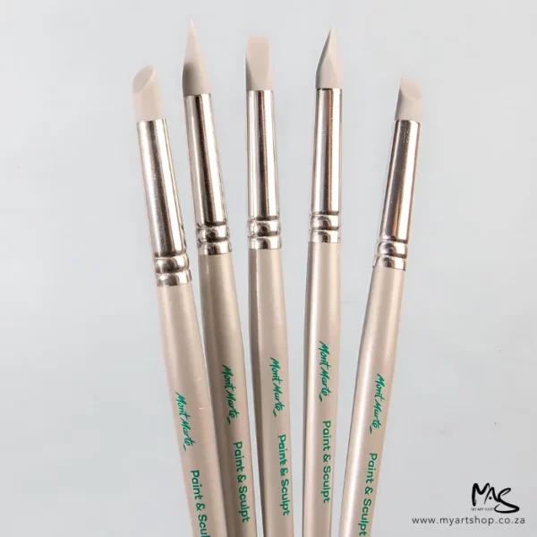 The Mont Marte Paint and Sculpt Shapers are seen loose in the frame. The are coming in from the bottom of the frame and the rubber tips are facing the top of the frame. The handles are beige and have the Mont Marte logo printed on them in green. On a light grey background.