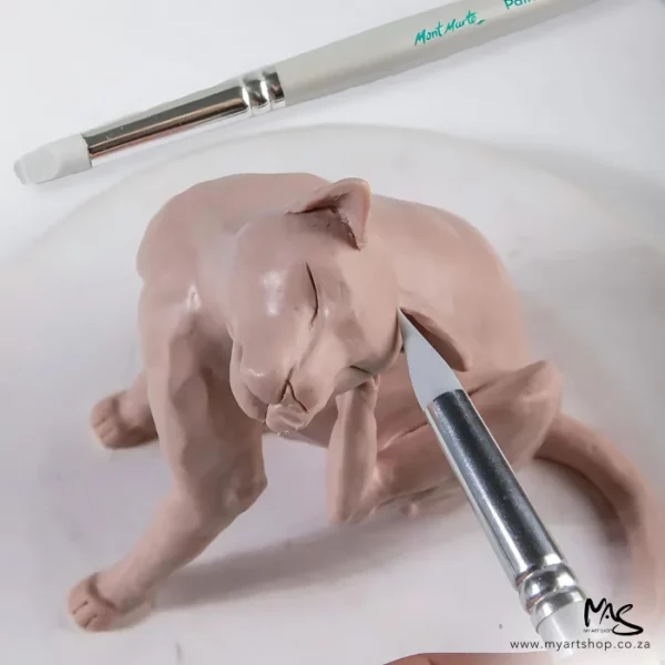 A single shaper from the Mont Marte Paint and Sculpt Shaper Set 5 piece can be seen, being using to assist with a clay mold of a cat which is beige, There is a paint shaper in the background.