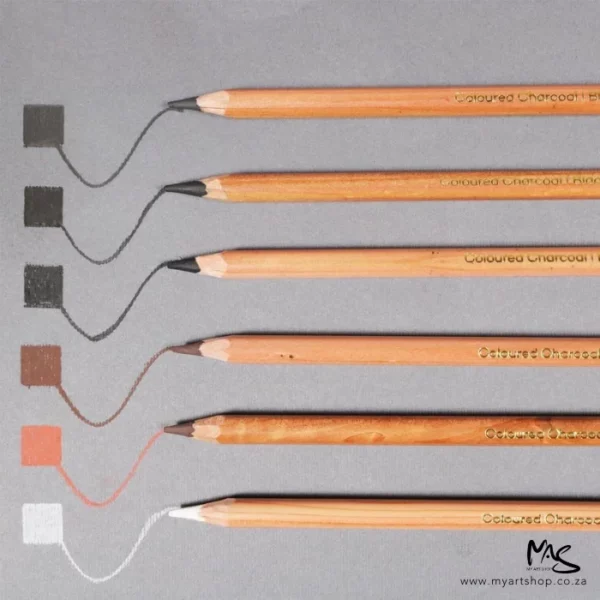 6 loose pencils from the Mont Marte Signature Coloured Charcoal Pencil Set are shown in the frame. The pencils are laying horizontally above one another along the right hand side of the frame and are cut off by the right hand side of the frame. There are pencil lines in front of the lead. On a light grey background.