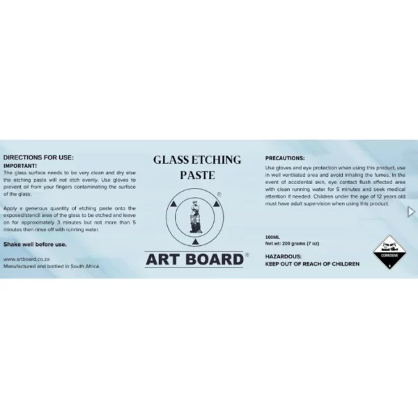 The label from a bottle of Artboard Glass Etching Paste 100ml is shown horizontally, across the center of the frame. The label is blue and has black text and the Artboard Logo in the center. There are instructions and precautions for use. On a white background.