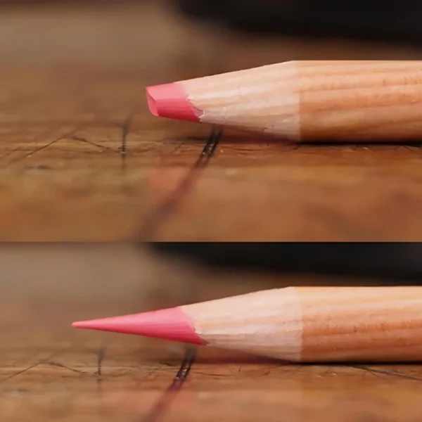 A clsoe up of two pencils leads. The top pencil has a broken lead and teh bottom pencil has a sharpened lead that was sharpened using the Derwent Super Point Mini Manual Sharpener. The pencils are laying horizontally and have a coloured pink lead.