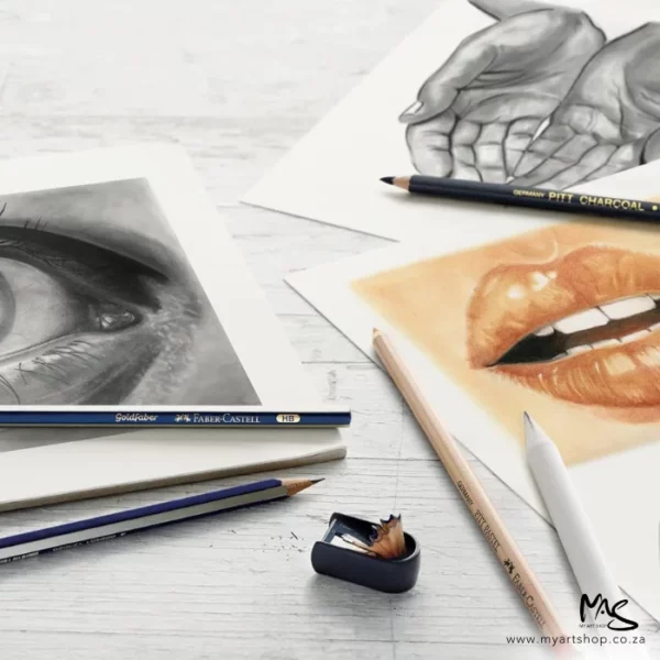 A picture of two open hands, a mouth and an eye is shown in the frame with various pencils laying on top of the drawing. The drawing is showing how the contents of the Faber Castell Charcoal Sketch Set can be used.