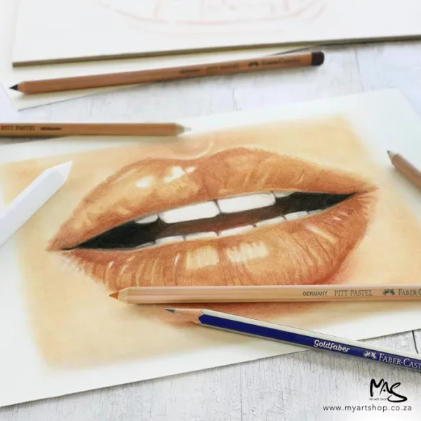 A close up of a picture of a persons lips that were drawn using the Faber Castell Classic Sketch Set. There are various pencils laying on top of the picture. The image is cut off by the frame.