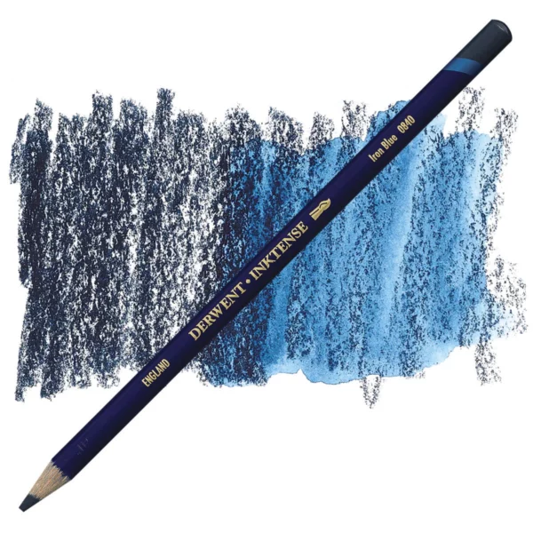 A single Iron Blue Derwent Inktense Colour Pencil is shown diagonally across the center of the frame. The pencil is pointing with it's lead facing towards the bottom left hand corner. The barrel of the pencil is blue and the end of the pencil is colour dipped to match the colour of the lead for easy identification. There is text down the barrel of the pencil with the colour name and brand name. There is a colour swatch of the pencil in the background, that runs horizontally across the center of the frame. The image is center of the frame and on a white background.