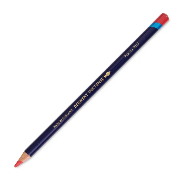 A single Paprika Derwent Inktense Colour Pencil is shown diagonally across the center of the frame. The pencil is pointing with it's lead facing towards the bottom left hand corner. The barrel of the pencil is blue and the end of the pencil is colour dipped to match the colour of the lead for easy identification. There is text down the barrel of the pencil with the colour name and brand name. On a white background.