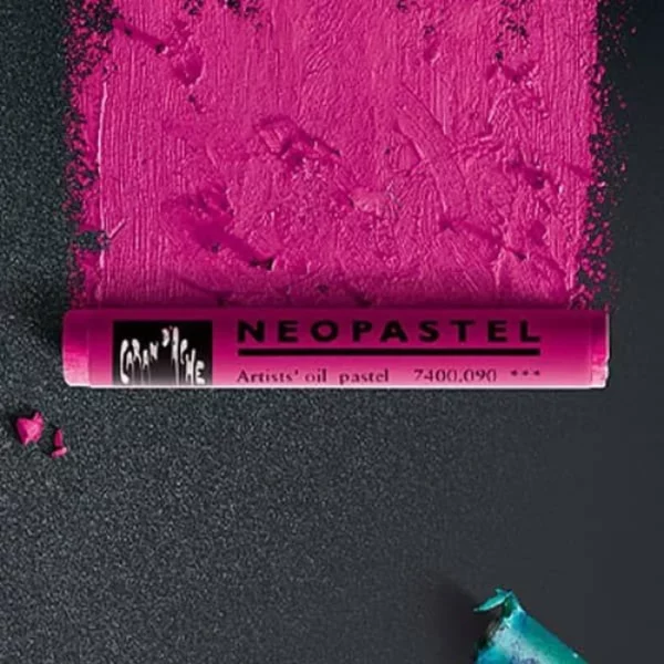 A single pink Caran D'Ache Neopastel is shown horizontally across the middle of the frame. It is laying on a black piece of paper that has the pink pastel drawn onto it in a colour swatch block above the pastel. You can see the texture of the oil pastel.