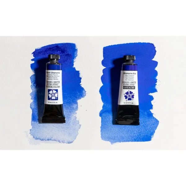 There are 2 tubes of paint, laying on top of two blue colour swatches across the center of the frame horizontally. The tube on the left is a tube of Daniel Smith Extra Fine Gouache Paint and the tube on the right is a Daniel Smith Watercolour Paint in the same blue colour. The swatches show you that the Gouache paint is far more opaque than the watercolour. On a white background.