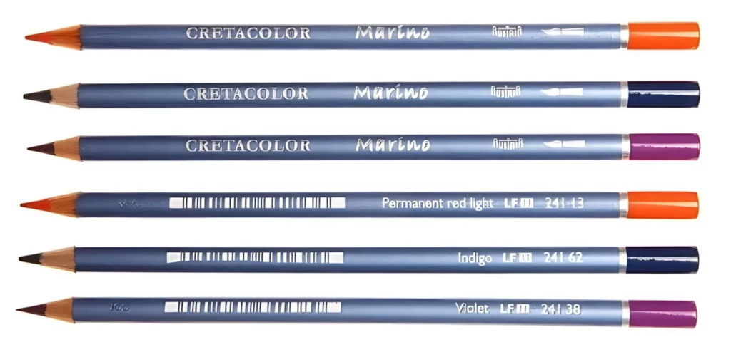 cretacolor marino pencils are in the center of the image. they are horizontal across the picture. their nibs are facing the left hand side of the image. the wrap around each pencil is a metallic blue color and the ends show what colour the pencil core is. the writing on the pencil is in white and is visable on the pencil. the top three are front facing and the bottom three the back of the pencil is facing the image. they are on a white background