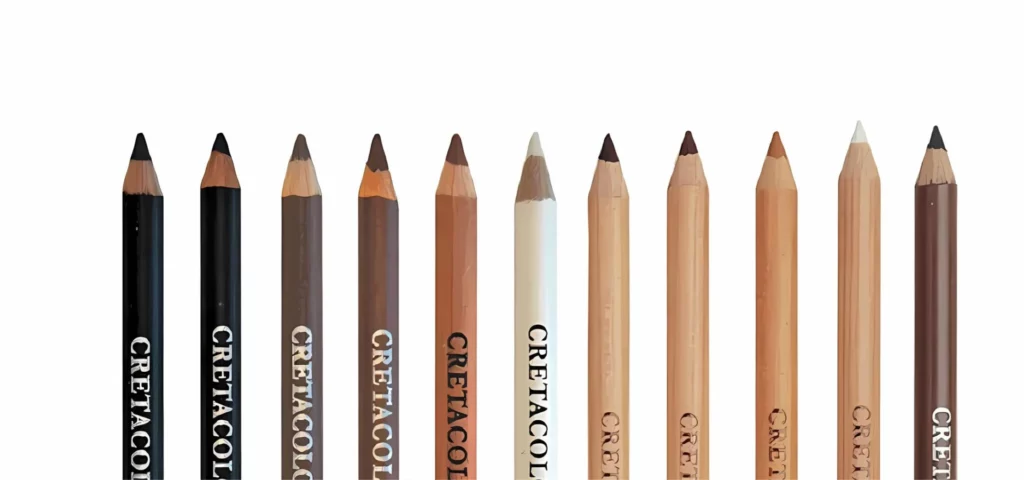 at the bottom of the image.twelve cretacolor sketching pencils are lying equal distance apart all facing upward nib to the top of the image. the three on the left are black encased then they are all brown encased pencils. they all have their names visable on the pencils in a white writing. they are all on a white background.