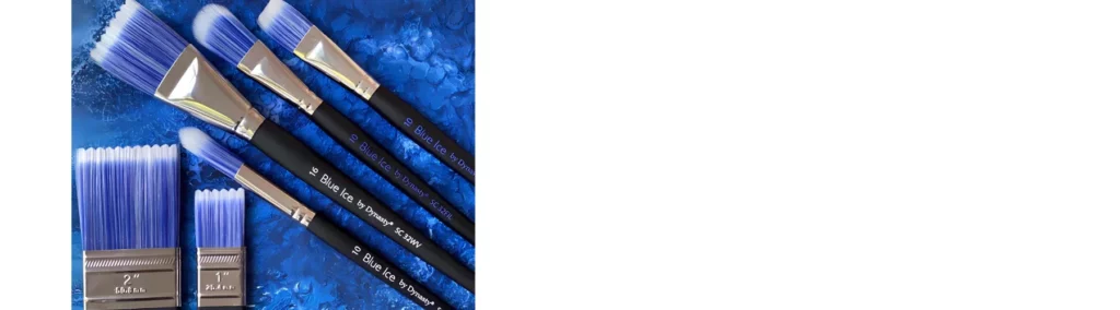 in the centre of the image  six dynasty blue ice brushes. four are sitting at an angle towards the top left corner and two are sitting vertical at the bottom left corner. they have black stems, silver ferrules and blue and white bristles. they are on a blue background