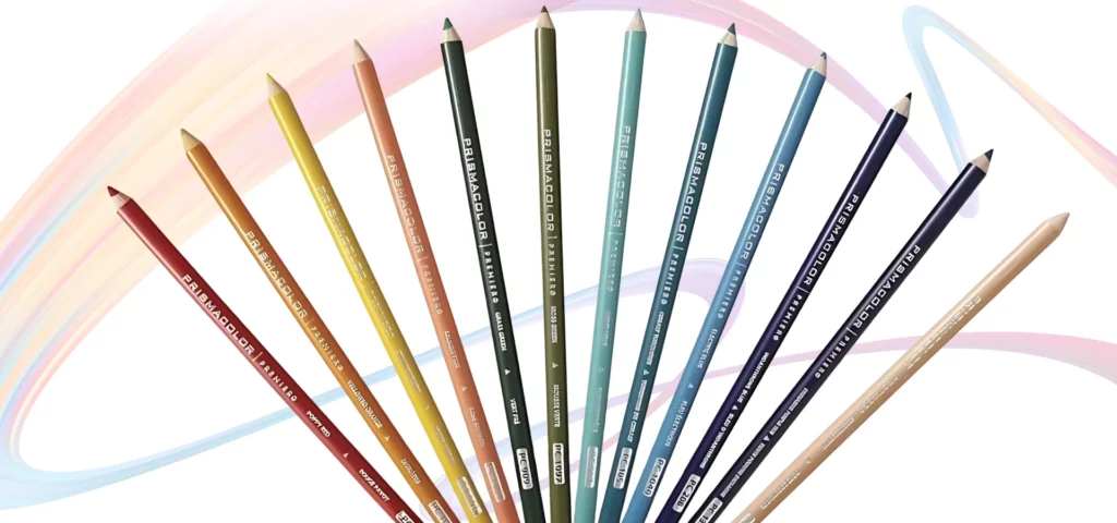 prismacolor pencils are shown splayed out in the centre of the image from the bottom of the image, they are in a rainbow order and their nibs are facing the top of the image. their name is clearly visable on each pencil. they are in the shape of a fan. they are on a very faint rainbow squiggle on a white background