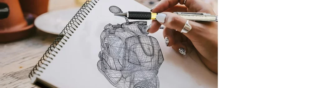 in the center of the image there is a person draing a hand using a mechanical pencil. they are crosshatching and shading the image. on an open ringbound sketchbook. sitting above a wooden work surface. it is a close up of a hand