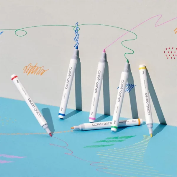 There are 6 Copic Acrea Paint Markers shown in the frame. They are standing up against a wall that has been drawn on using the markers.