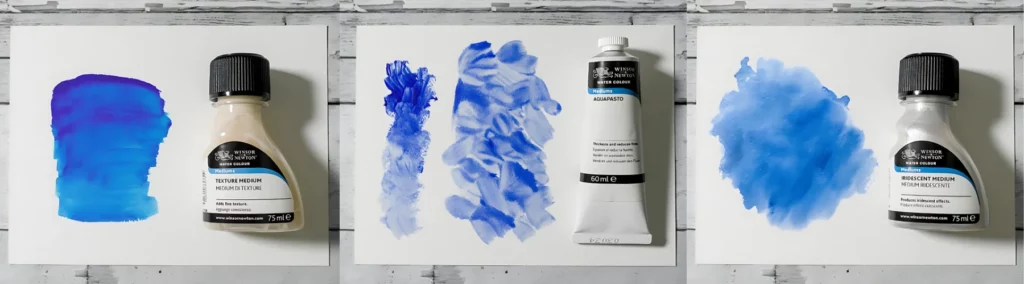 the left hand image is of a blue colour swatch next to a bottle of medium resting on watercolour paper on a wooden table.. the center image is of two blue swatches on watercolour paper next to the medium lying on a wooden table and the third image is of a blended blue swatch lying next to the medium on watercolour paper on a wooden table. they are all showing how the products work