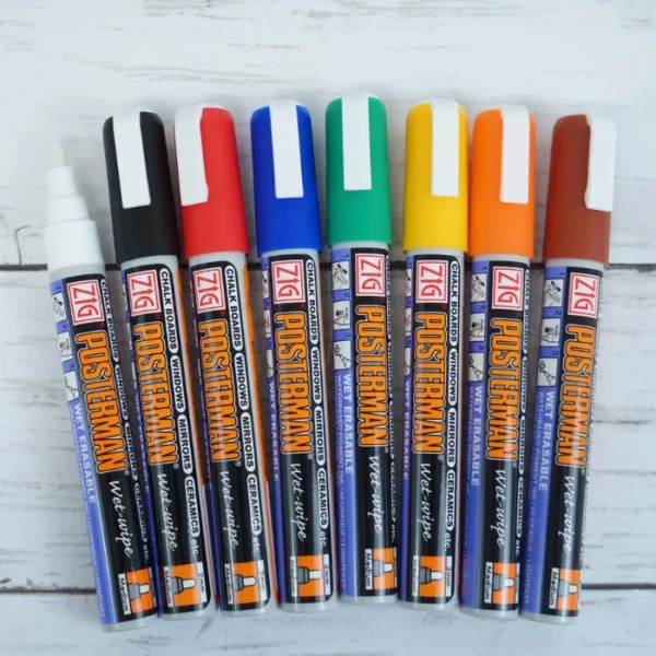 A Zig Posterman Wet Wipe Paint Marker Medium Set of 8 is shown in the center of the frame. there are 8 markers in a clear plastic case. Each marker is a different colour. The colour of the cap denotes the colour of the marker. On a white background.