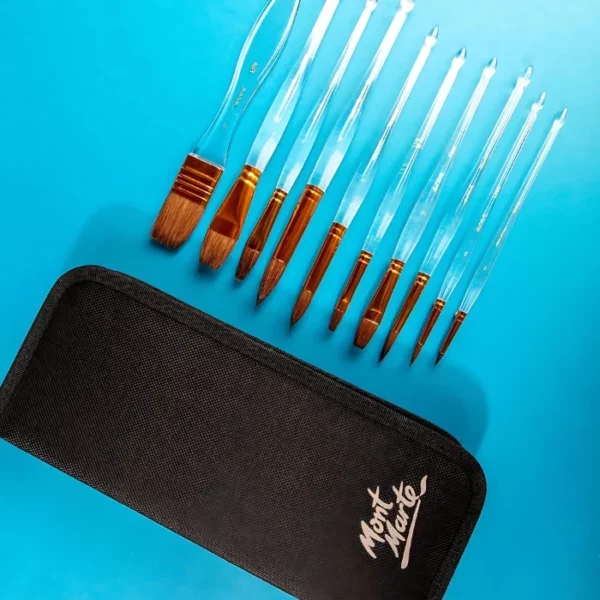 A Mont Marte Acrylic Handle Watercolour Brush Set is shown in the frame. The brushes are loose at the top of the frame, lined up next to each other diagnoally. The black zip up case is shown at the front of the frame, it has the Mont Marte logo printed on it. The brushes have clear plastic handles. On a white background.