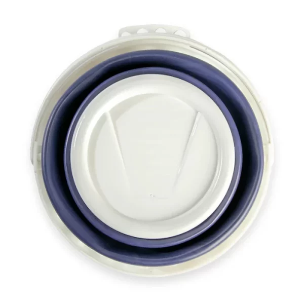 A Mont Marte Signature Collapsible Brush Washer is shown in it's collapsed state in the center of the frame. The washer is made from a white and blur plastic with a scalloped lip. On a white background.