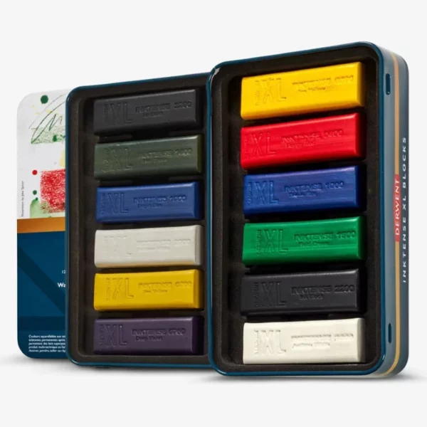 The inside tray of a Set of 12 Derwent Inktense XL Blocks is shown horizontally in the center of the frame. The block sticks are lined up next to each other. Each stick is a different colour. The tin lid is seen popping out from behind the tray. On a white background.