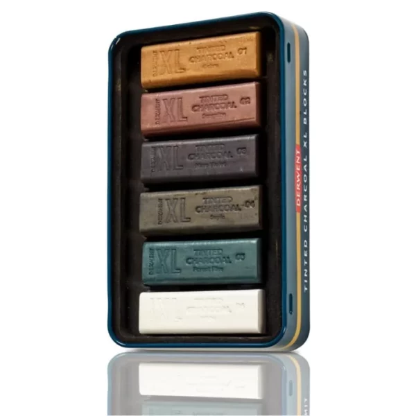 The bottom tray of a Set of 6 Derwent Tinted Charcoal XL Blocks is shown vertically in the center of the frame. There are 6 XL sticks in the tray and are held in place with a black, molded plastic piece. On a white background.